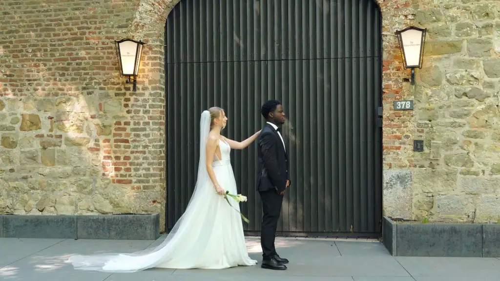 Braut und Bräutigam vor altem Tor bei Hochzeit in Aachen.