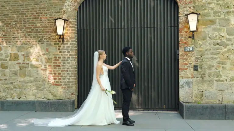 Braut und Bräutigam vor altem Tor bei Hochzeit in Aachen.