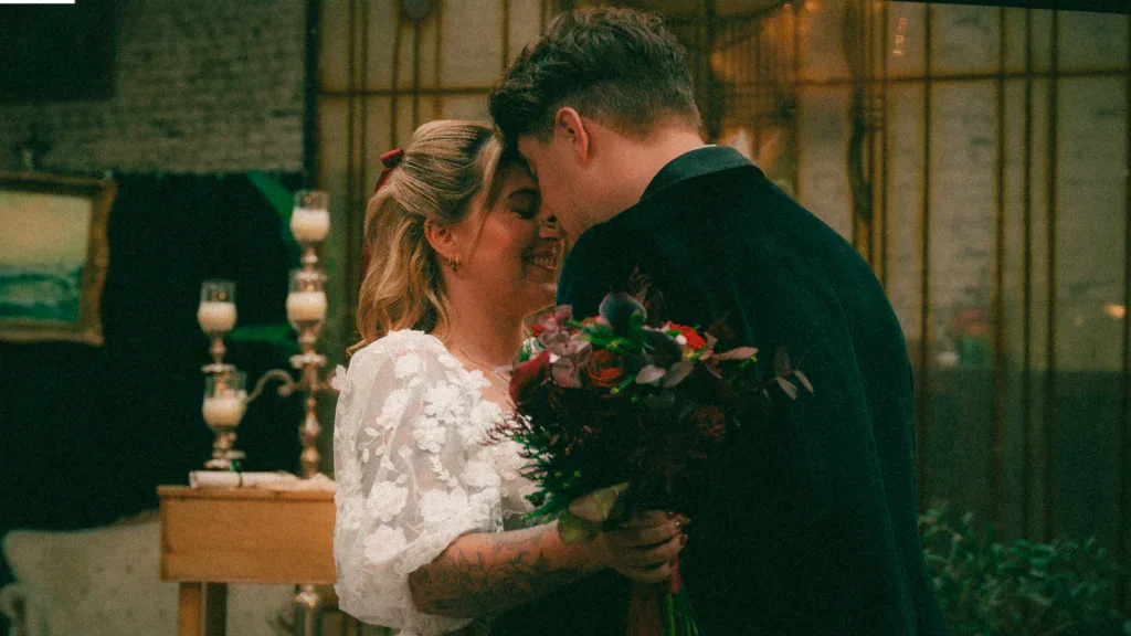 Hochzeitspaar umarmt sich liebevoll bei Feier.